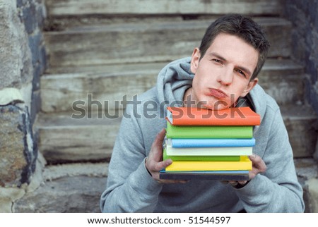 Handsome student is overwhelmed with books.