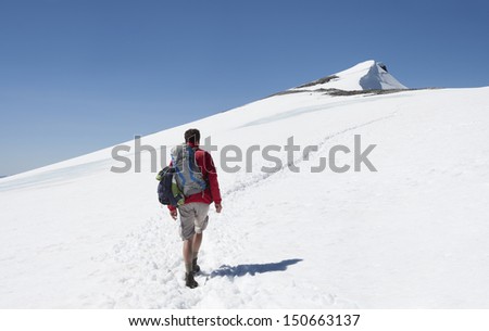 A male hiker on his way to the summit of Glittertind mountain in the snow (Jotunheimen National Park, Norway)