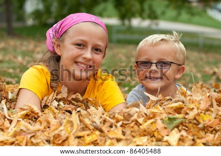 Cute Sister Brother Lay in Autumn Leaves