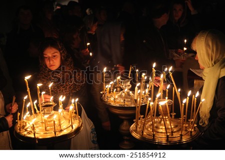PRAGUE, CZECH REPUBLIC - MAY 5, 2013: Orthodox believers light candles during an Orthodox Easter night service in front of the Dormition Church at the Olsany Cemetery in Prague, Czech Republic.