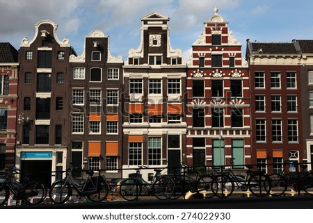 AMSTERDAM, NETHERLANDS - AUGUST 9, 2012: Bicycles parked in front of the traditional Dutch brick houses on Rokin Street in Amsterdam, Netherlands.