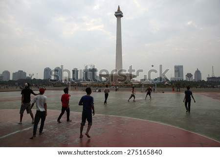 JAKARTA, INDONESIA - AUGUST 17, 2011: Children play football at the foot of the National Monument or the Monas in Jakarta, Central Java, Indonesia.