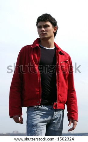 Young male model in a red jacket waiting for somebody