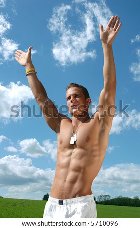 Muscular sexy man with army tags with blue sky behind