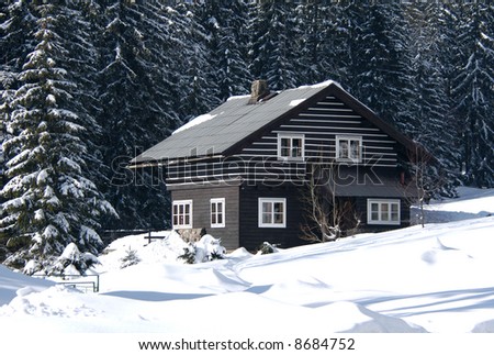 Snow-covered ski resort house in the firry forest in the Czech mountains