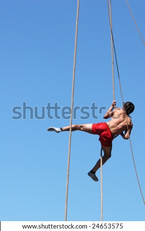 PRAGUE, JUNE 17 - Shirtless athlete climbing up the rope during a rope-climbing competition in Prague, Czech Republic, on June 17, 2008