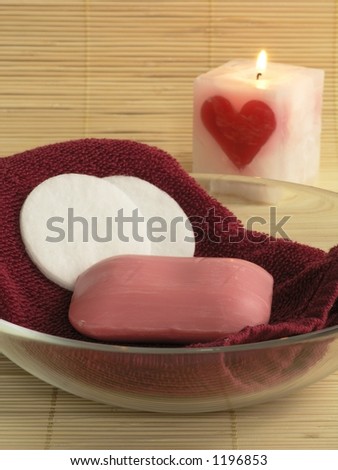 Towel,soap and cosmetic pads in a bowl.