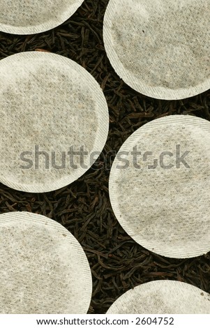 Close-up of black tea leaves and round tea bags