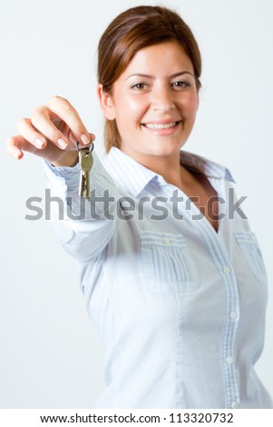 Young happy smiling business woman or real estate agent showing keys from new house, isolated on white background