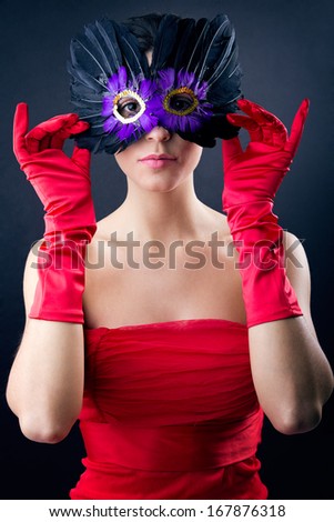 Portrait of Sophisticated woman with red dress and carnival mask