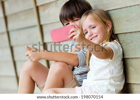 Similar – Image, Stock Photo brother taking a picture of his sister with mobile phone