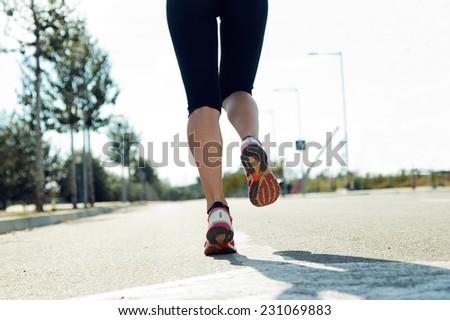 Outdoor portrait of runner feet running on road closeup on shoe.