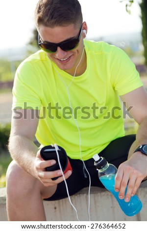 Portrait of handsome young man listening to music after running.