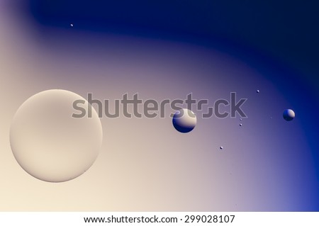Planet system with oil drops on water surface.