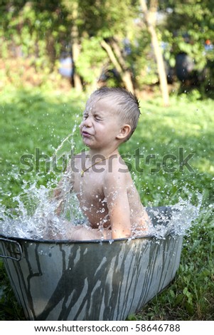 little boy washing in old washing tub outdoor