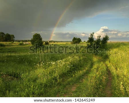 rural landscape with storm cloud and rainbow