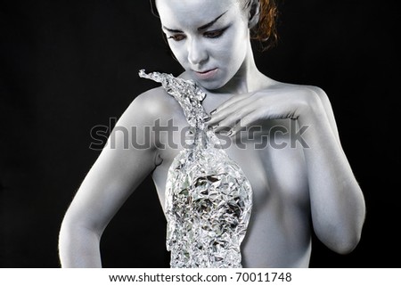 Frozen silver woman looking at side on black background