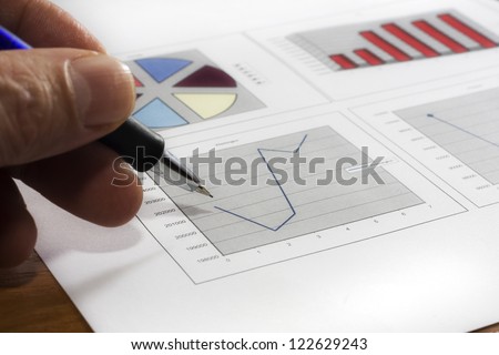 Colorful sales charts with pen.