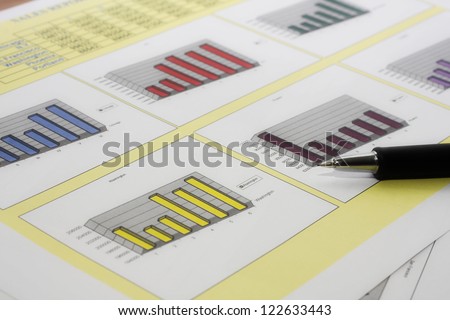 Colorful sales charts with pen.