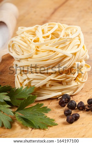 Nests of dry pasta on wooden table.