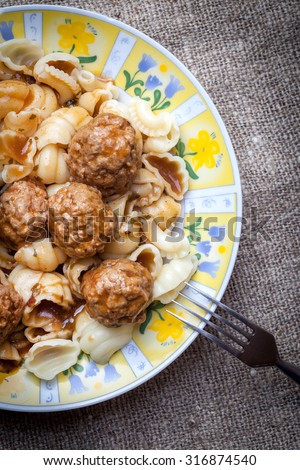 Meatballs with pasta on a porcelain plate.