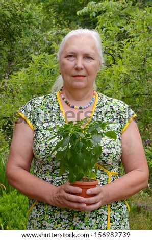 Middle-aged woman getting ready to plant seedlings of pepper in the garden