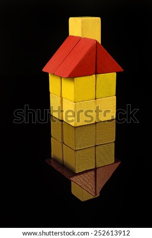 House of wooden blocks, traditional toy on black background