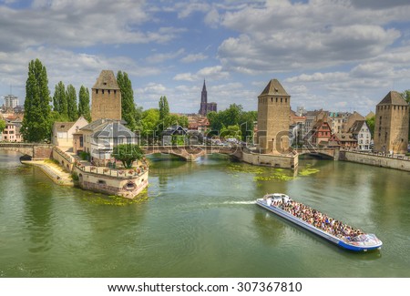 STRASBOURG, FRANCE - JULY 14, 2015: People Tourists viewing from a pleasure boats place in Strasbourg. The historic center of Strasbourg is UNESCO World Heritage Site, medieval bridge Ponts Couverts.