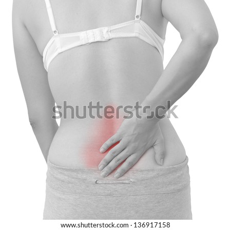 Acute pain in a woman back. Female from behind holding hand to spot of back pain. Concept photo with Color Enhanced skin with read spot indicating location of the pain. Isolation on a white background