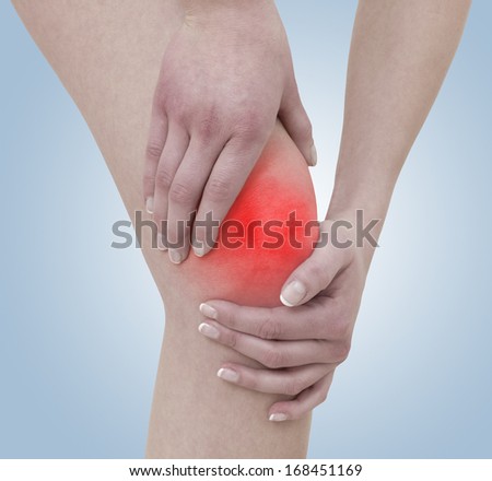 Acute pain in a woman knee. Concept photo with blue skin with read spot indicating pain.
