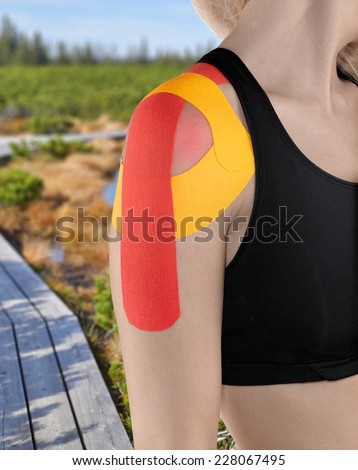 Physiotherapy treatment with therapeutic tape for shoulder pain, aches and tension. It is also used for prevention and treatment in competitive sports.Autumn Park Backgroun