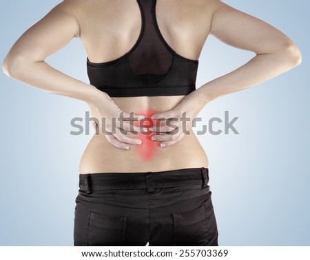 Woman with both palm around back to show pain and injury on back area. Medical health care concept.
