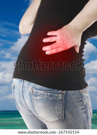 Woman holds a hand on back pain. Backache. Medical concept