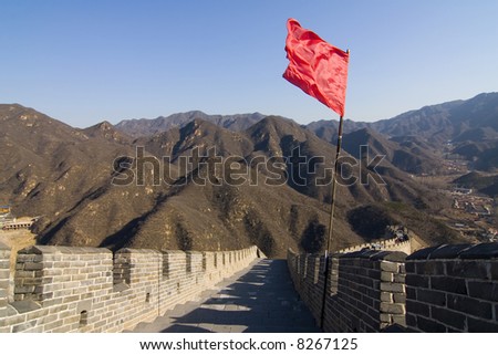 View of the Great Wall of China with red flag and blue sky