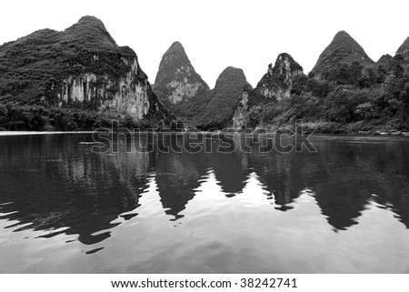 Reflections of karst mountains in the Yulong River near Yangshuo, China in black and white