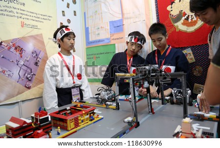 SUBANG JAYA - NOV 10:Unidentified students from Japan show a remote sensing robotic system that control cars to prevent collisions at the World Robot Olympaid on Nov 10, 2012 in Subang Jaya, Malaysia.