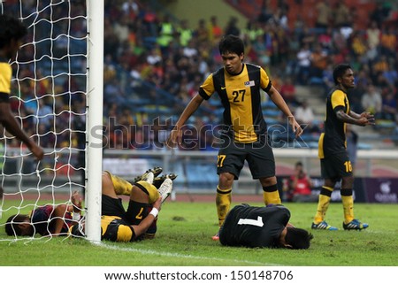 KUALA LUMPUR - AUGUST 10: Malaysia\'s defenders (yellow) and goalkeeper stops a FC Barcelona attack at the Shah Alam Stadium on August 10, 2013 in Malaysia. FC Barcelona wins 3-1.