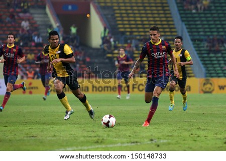 KUALA LUMPUR - AUGUST 10: FC Barcelona's Cristian Tello (maroon/blue) dribbles the ball in a match vs Malaysia at the Shah Alam Stadium on Aug 10, 2013 in Kuala Lumpur, Malaysia. Barcelona wins 3-1.