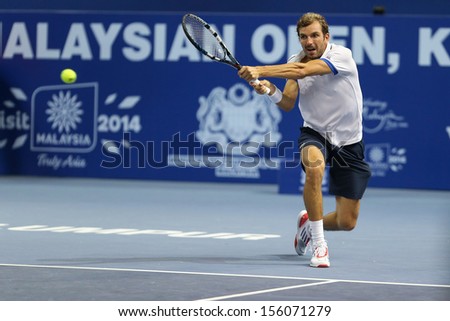 KUALA LUMPUR - SEPTEMBER 27: Julien Benneteau volleys a return to Adrian Mannarino in a semi-final match of the Malaysia Open 2013 tennis played at the Putra Stadium, Malaysia on September 27, 2013.
