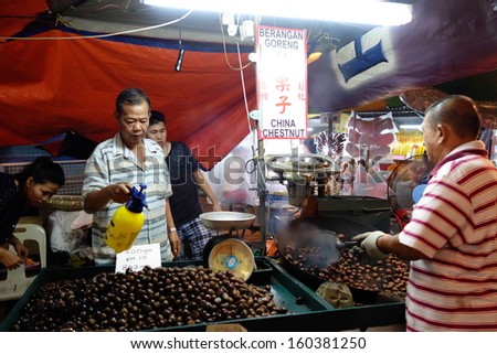 AMPANG - OCTOBER 9: Vendors selling roasted chest-nuts prepare the nuts for sale at the Kau Ong Yah Temple in Ampang, Malaysia during the Nine Emperor Gods festival on October 9, 2013.