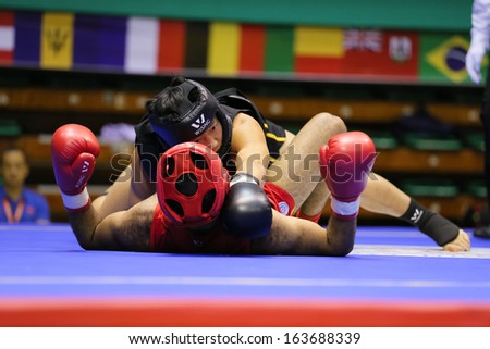 KUALA LUMPUR - NOV 05: China\'s Zhang Kaiyin (black) takes down Egypt\'s Ahmed Ebrahim in the Sanda boxing event, 12th World Wushu Championship on November 05, 2013 in Kuala Lumpur, Malaysia.