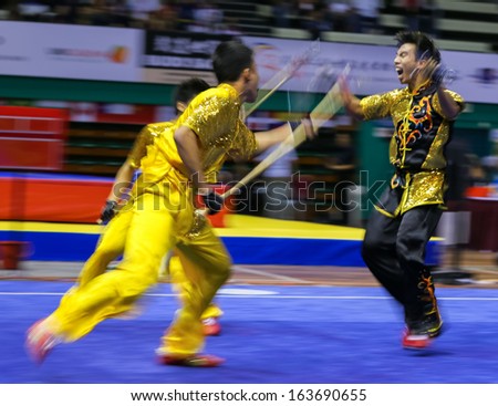 KUALA LUMPUR - NOV 05: Members of Singapore\'s dalian team performs a fight scene in the Men\'s Dual Event at the 12th World Wushu Championship on November 05, 2013 in Kuala Lumpur, Malaysia.