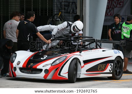 SEPANG, MALAYSIA - MAY 10, 2014: Driver CM Wong jumps into his race car during the pit-stop at the free practice session of the Malaysian Super Series Round 2 in Sepang International Circuit.