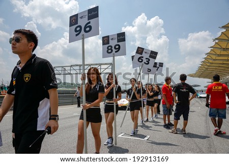 SEPANG, MALAYSIA - MAY 11, 2014: Grid girls leaves the track to start off the Lamborghini Super Trofeo race, part of the Malaysian Super Series Rd 2 held at the Sepang International Circuit.