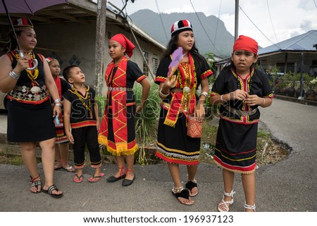 SARAWAK, MALAYSIA: JUNE 1, 2014: People of the Bidayuh tribe, an indigenous native people of Borneo, in traditional costumes, wait for the street parade to pass celebrating the Gawai Dayak festival.