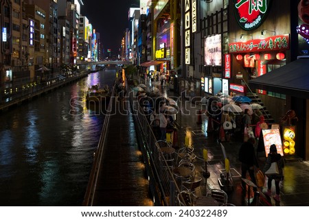 OSAKA, JAPAN - 30 NOVEMBER 2014: People line up outside a restaurant besides a river in Osaka. The vibrant nightlife is a tourist attraction in this second largest city in Japan.