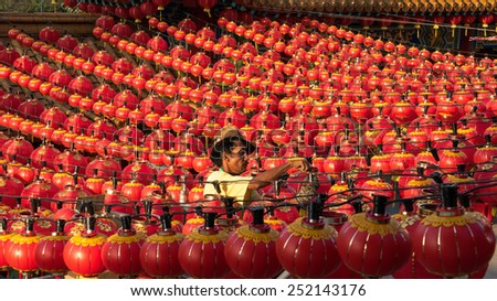 KUALA LUMPUR, MALAYSIA - FEBRUARY 08, 2015: An unidentified work hangs up hundreds of lanterns across the courtyard of the Thean Hou Temple in preparation for the coming lunar Chinese New Year.