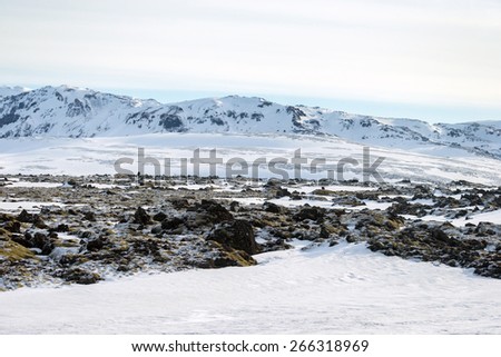 Scenic snow covered land and mountains in Iceland during winter.