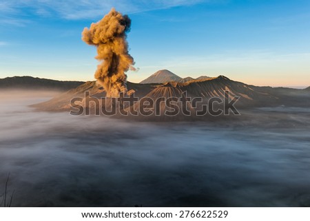 JAVA, INDONESIA - JULY 2, 2011: Mount Bromo erupts spewing out ash and smoke in the misty morning. Indonesia sits on the \'ring of fire\' with many active volcanoes and prone to earthquakes.
