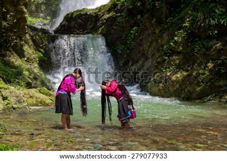 LONGJI, CHINA - MAY 24, 2010: Unidentified women wash their hair at a stream in the village. Red Yao ethnic minority women here regard keeping long hair as a sign of beauty..